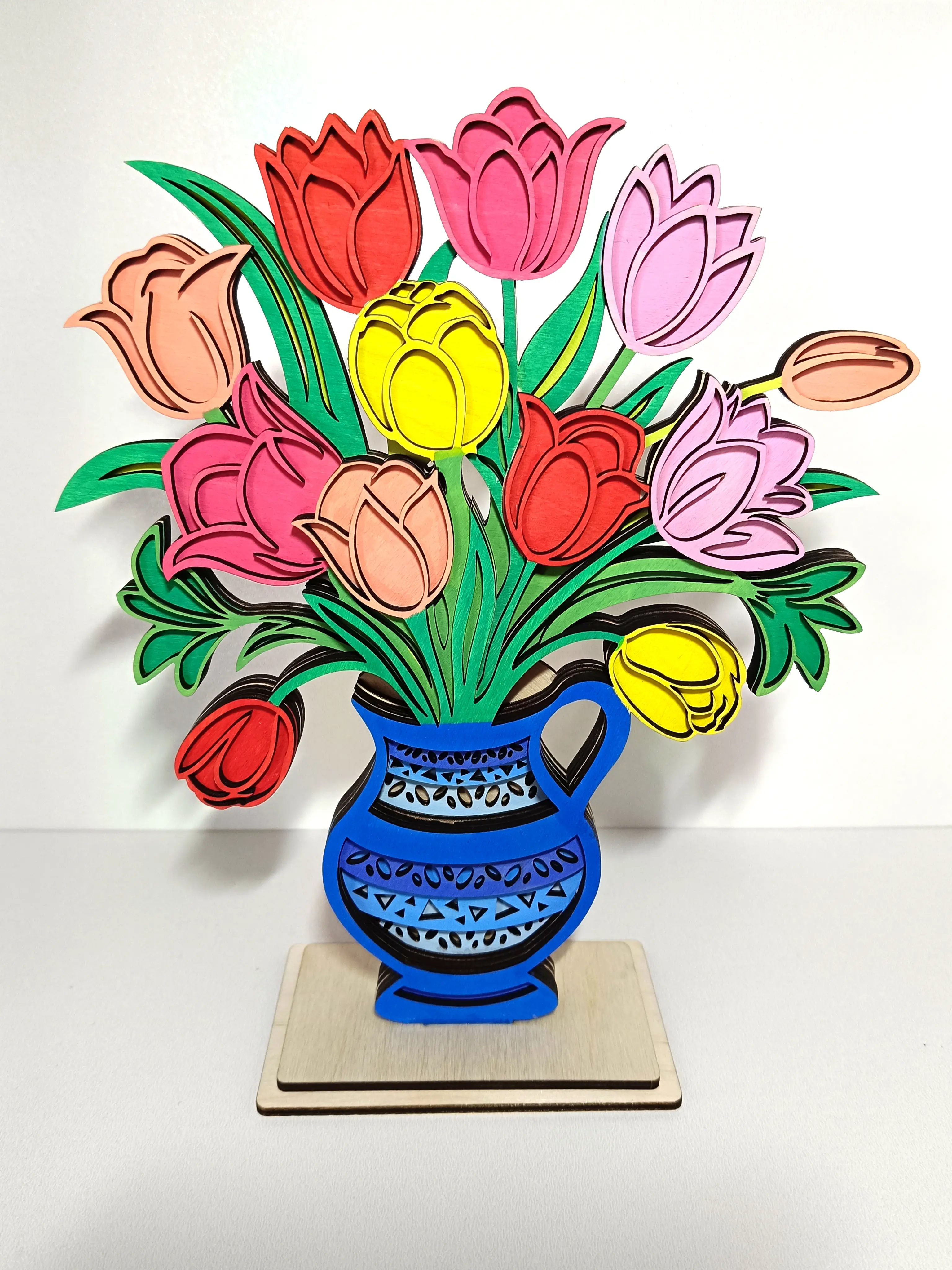 Drewniana dekoracja w formie kolorowego bukietu tulipanów w niebieskim wazonie na podstawce