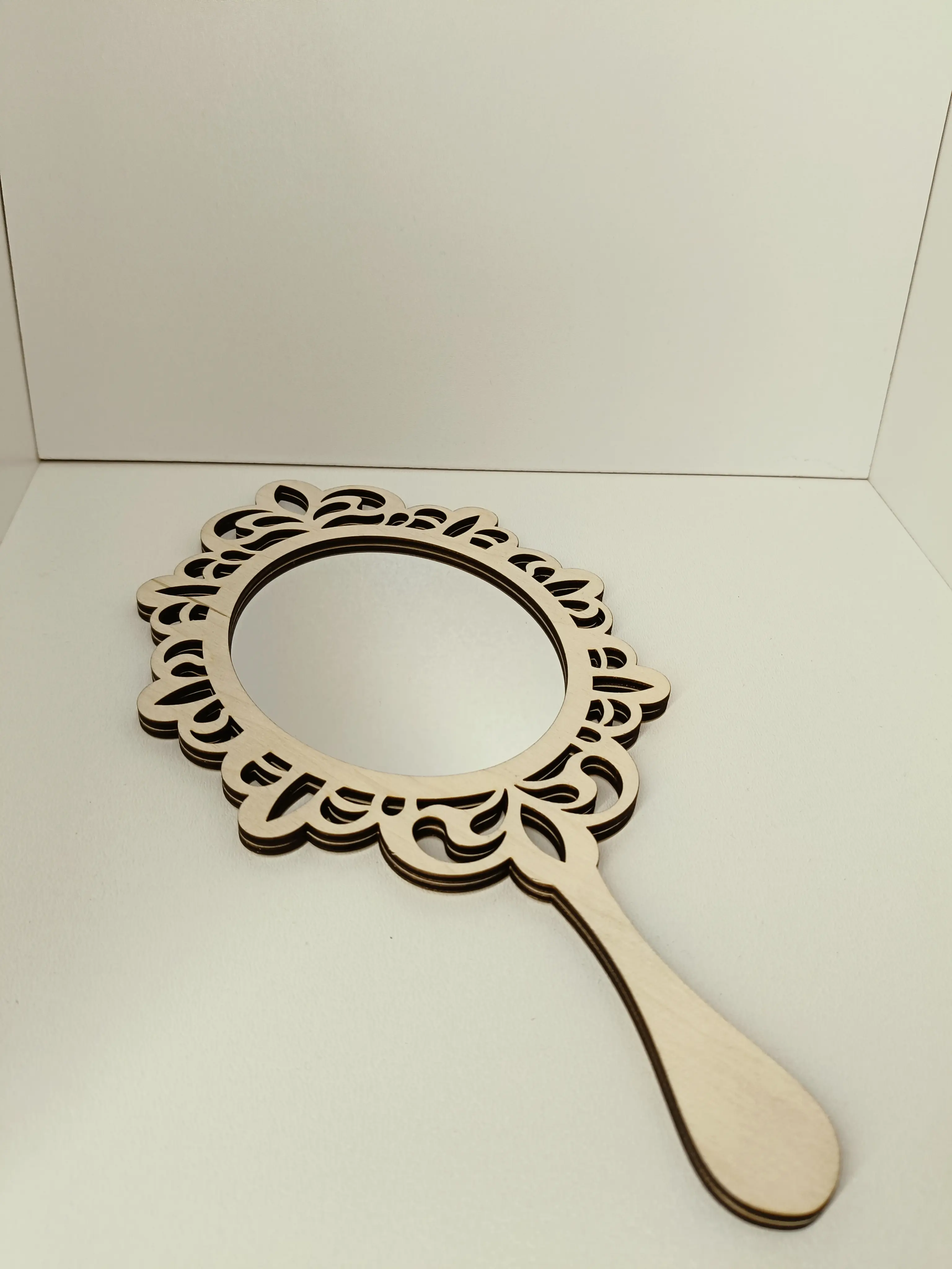 Drewniane lusterko ręczne z ozdobną ażurową ramką w stylu vintage