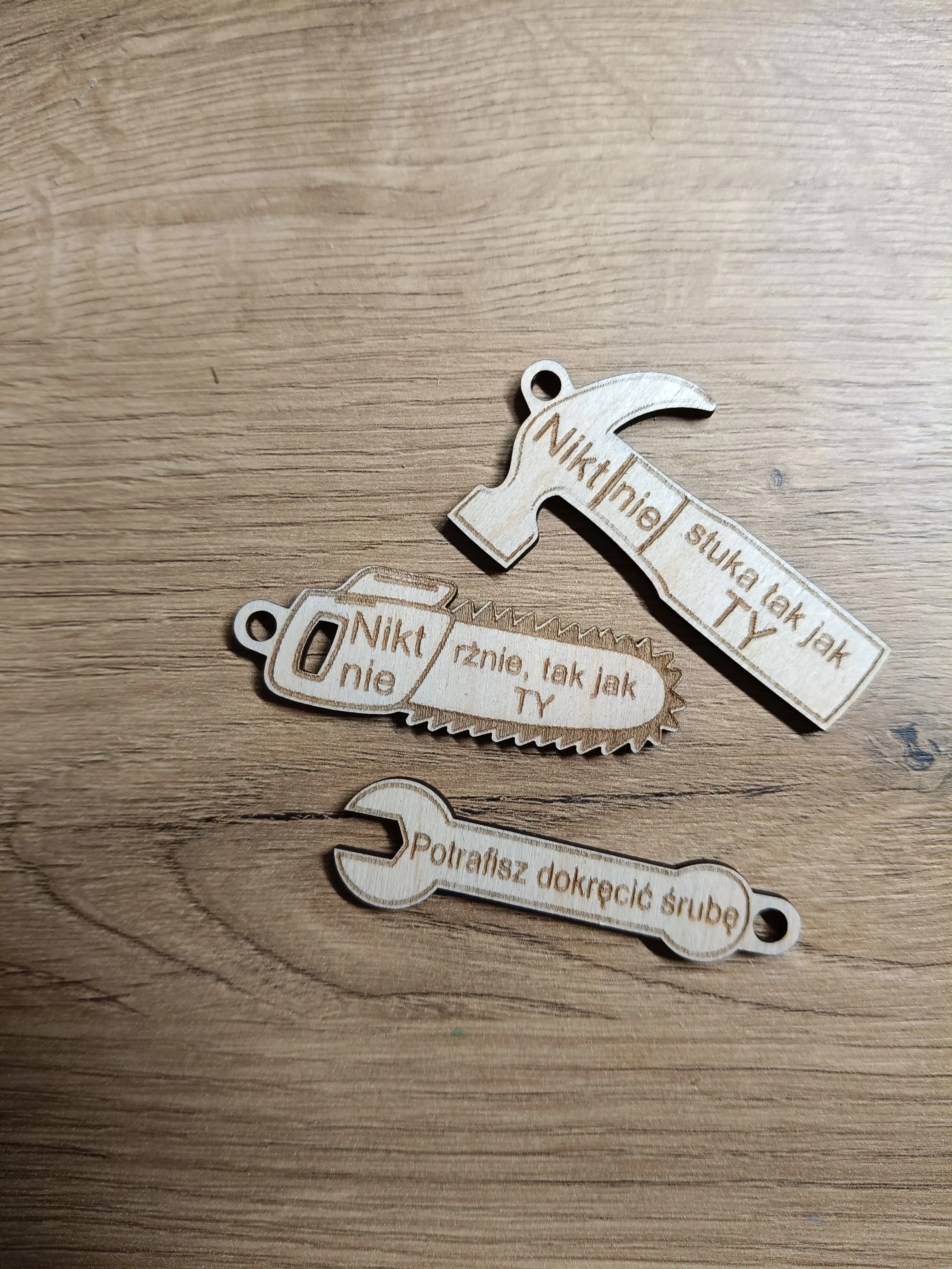 Drewniane breloki w kształcie młotka, piły i klucza francuskiego z humorystycznymi grawerami