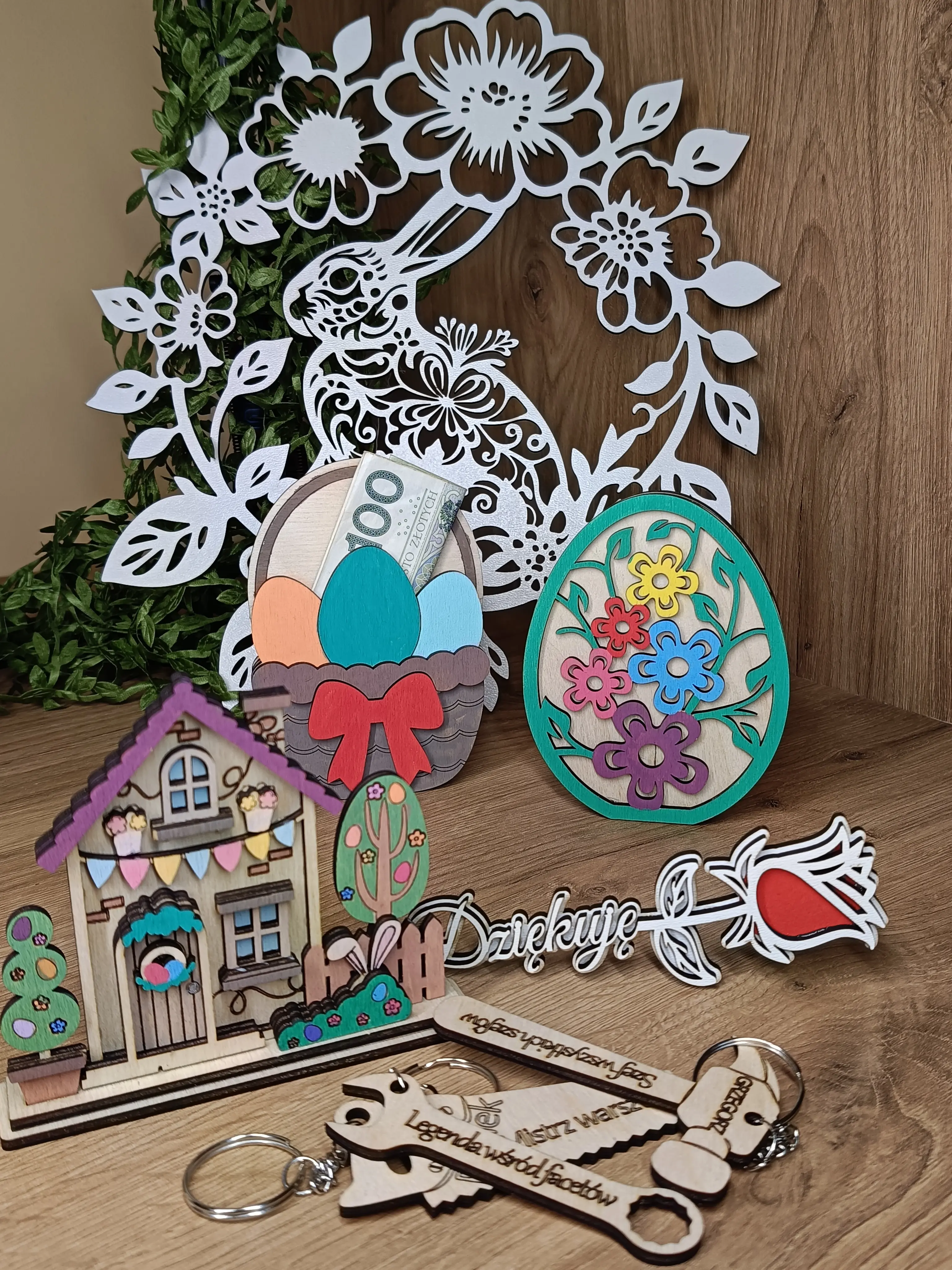 Wielkanocna kompozycja dekoracyjna z ażurowym królikiem, kolorowym jajkiem, koszyczkiem i domkiem